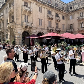 Brass band performing in a Malta town square during a local festival