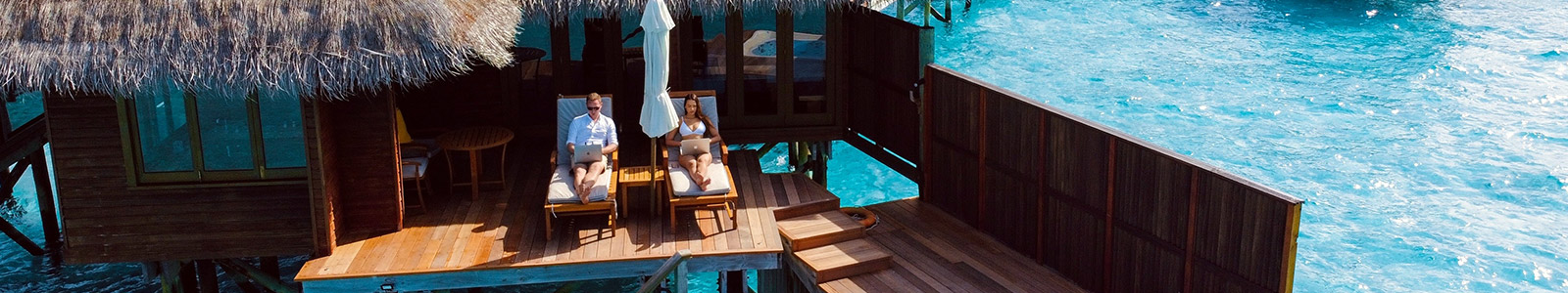 Couple lounging on an overwater bungalow
